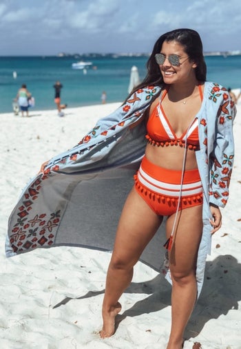 Reviewer is wearing the tassle bikini set in an orange and white color