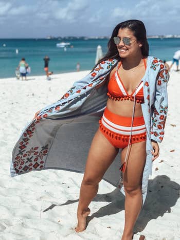 Reviewer is wearing the tassle bikini set in an orange and white color