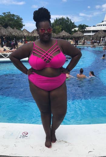 reviewer posing in pink bathing suit in front of pool