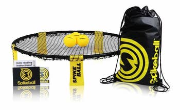 a small circular netted trampoline with a black and yellow storage bag and three small yellow balls