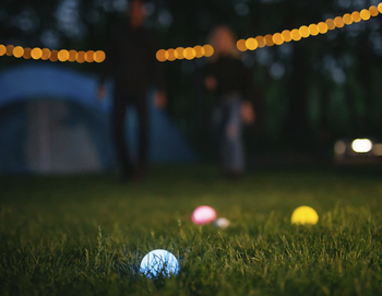 couple playing the game at night while camping