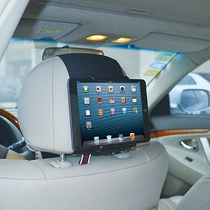 Tablet mount attached to car headrest with tablet inside