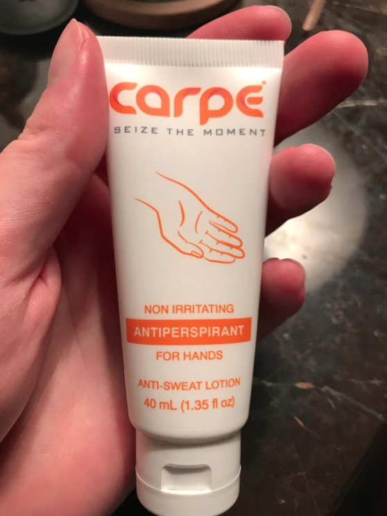 Reviewer holding the Carpe antiperspirant for hands 