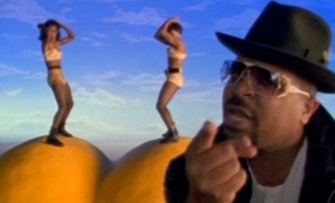 Two woman dance on top of giant peaches while Sir Mix-a-Lot raps into the camera