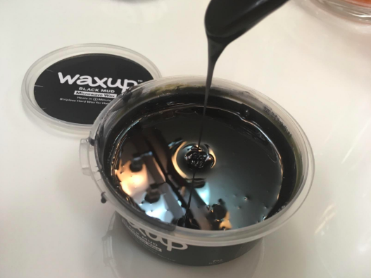 A reviewer dripping the melted wax from a stick
