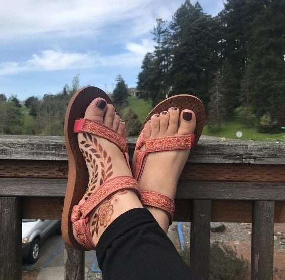 Reviewer wearing the Teva sandals in pink 