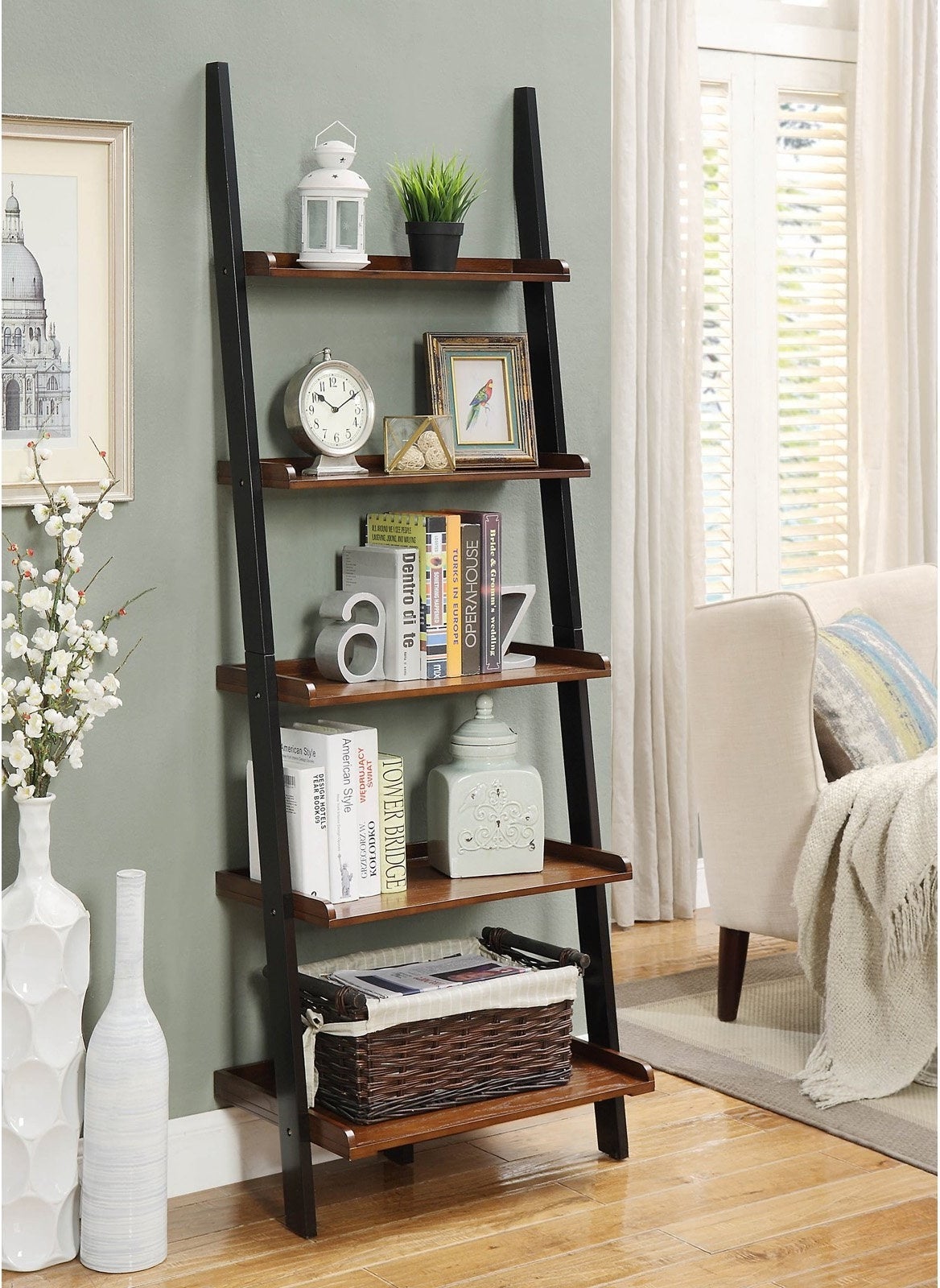 the ladder bookshelf in dark walnut with books and decor on it 