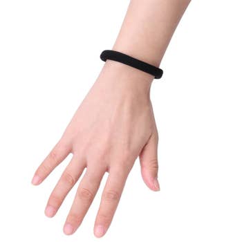 The thick, black hair tie on a wrist