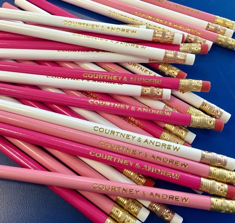 pile of pink, light pink, and white pencils imprinted with &quot;courtney and andrew&quot; in gold