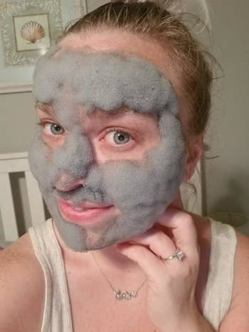 reviewer using foaming gray face mask