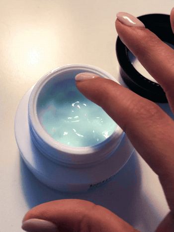 gif of buzzfeed editor dipping into blue gel-like moisturizer and rubbing it between her fingers