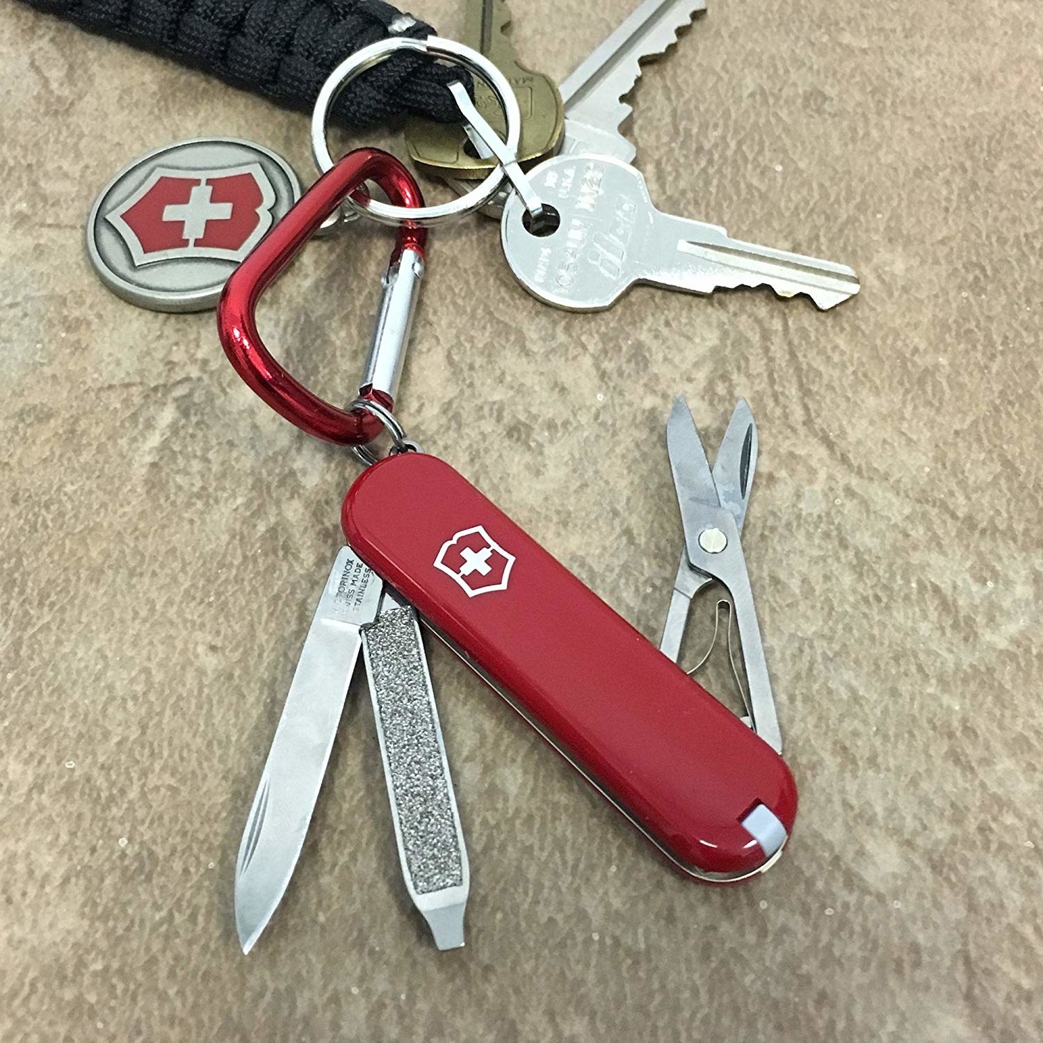 The Swiss Army Knife in Red on a key chain with the small scissors, nail file, and knife coming out of it