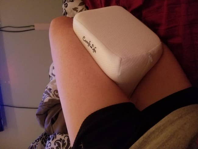 Reviewer with the white square pillow between their knees