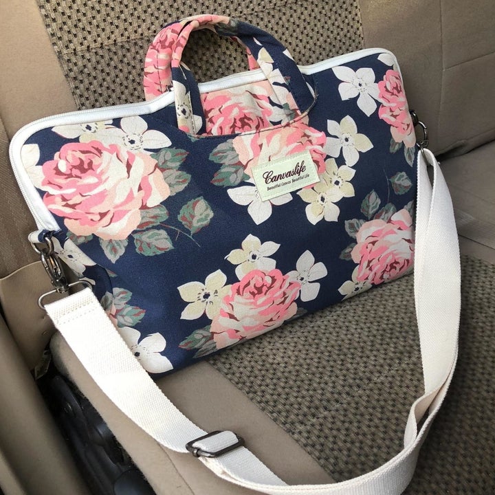reviewer image of zippered pink and navy floral bag with handles and white shoulder straps 