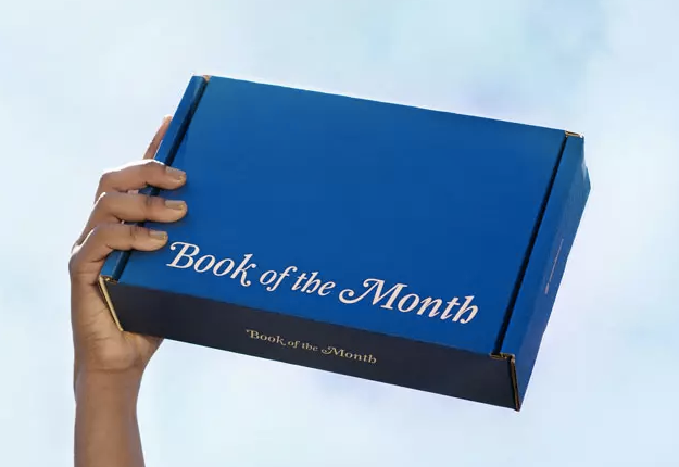 hand holds blue box that says book of the month