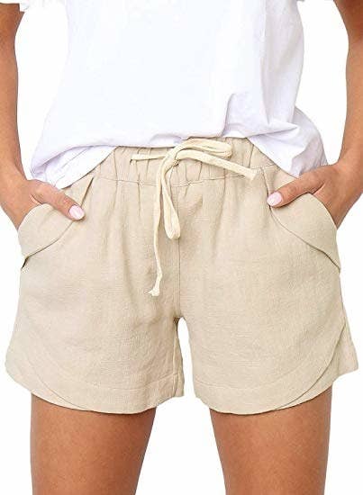 a model wearing the shorts in light tan with their hands in the pockets