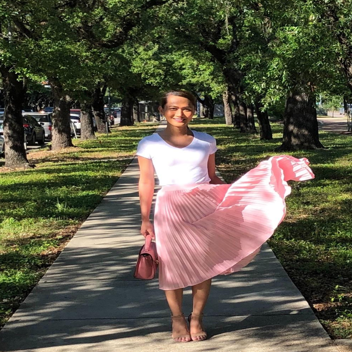 A different reviewer wearing the skirt in pink with a simple white tee