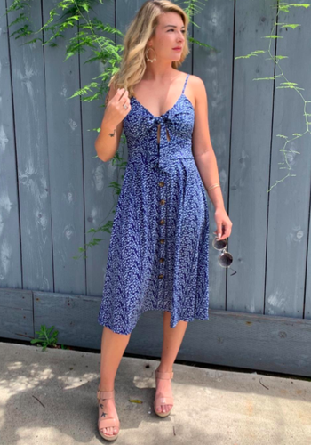 reviewer wearing the blue and white floral dress