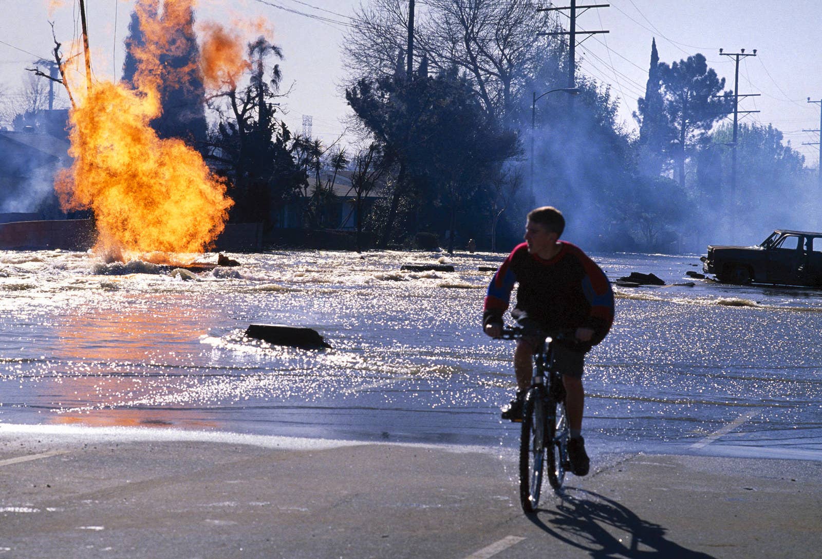 David Hume Kennerly / Getty Images A man bicycles through a flooded road, caused by the Northridge earthquake, on Jan. 17.
