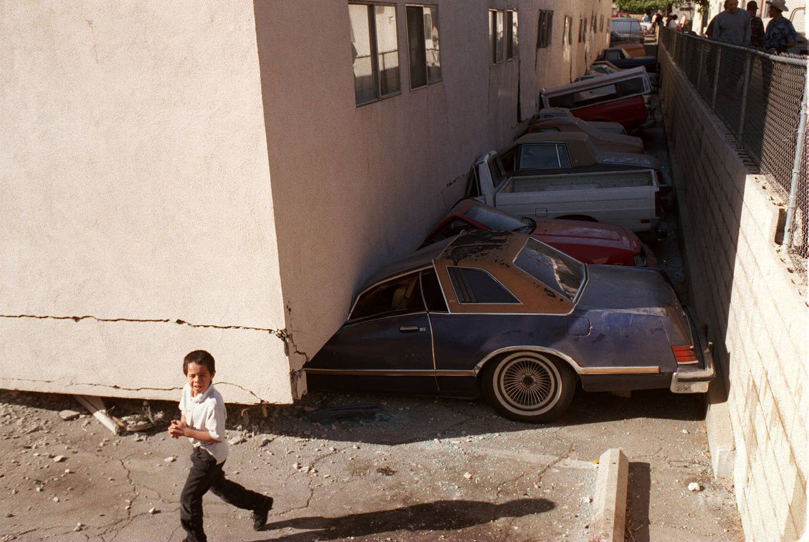 Rolando Otero / Getty Images Vehicles are left crushed under the Northridge Meadows apartment complex on Jan. 17.