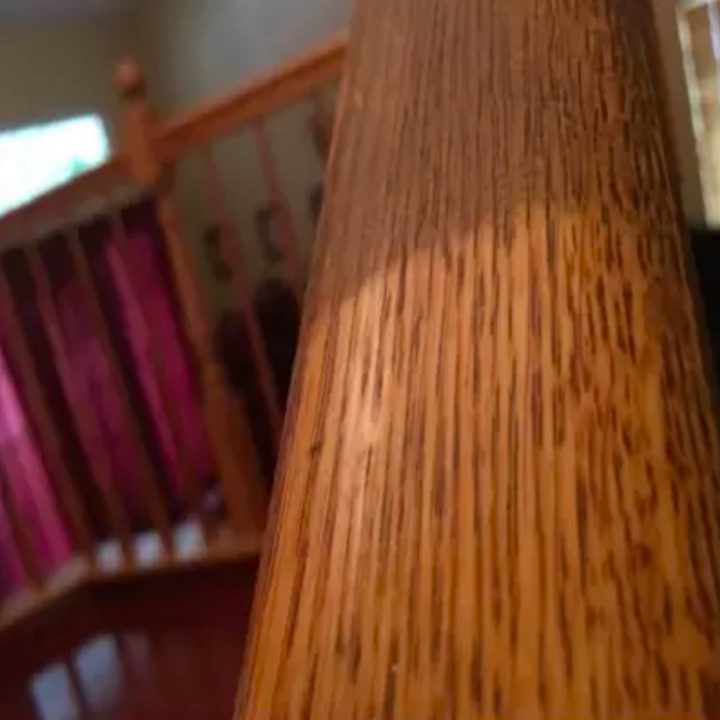 Wood banister shining clean after being wiped, with dark brown on areas that haven't been cleaned yet