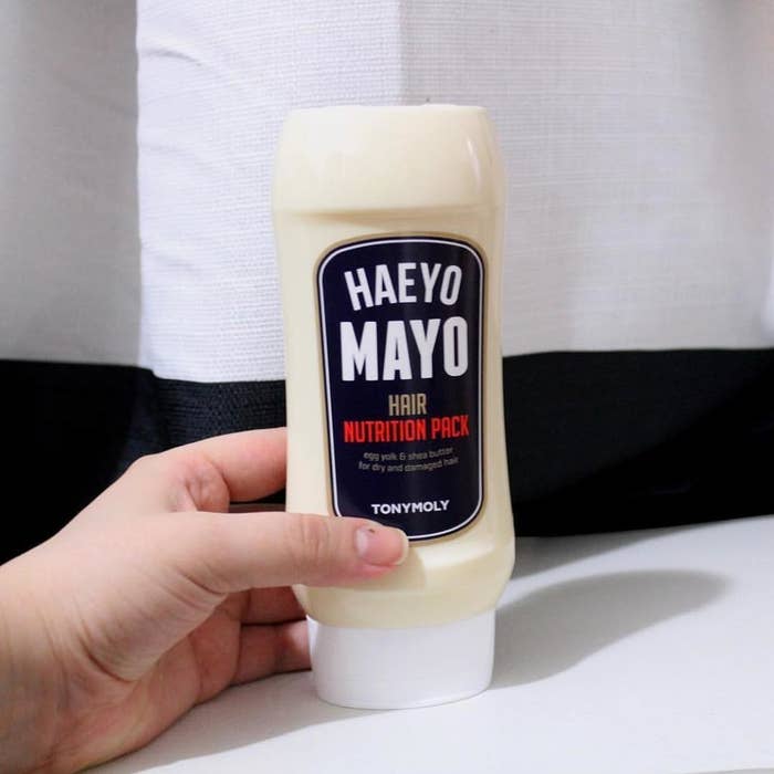Hand holding the hair mask, which is packaged like a real mayo bottle 