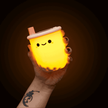 Gif of hand holding the light, which has moving boba pieces inside and a cute smiley face on the outside