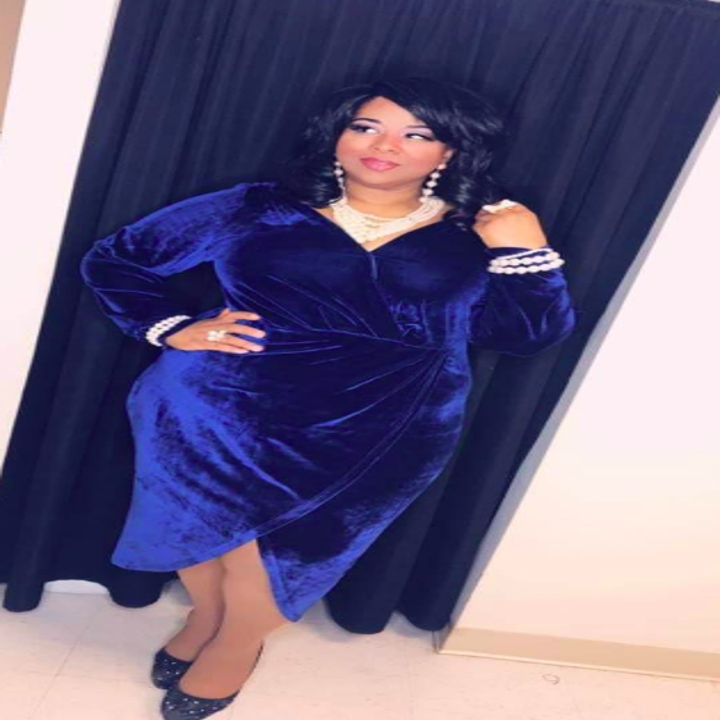 A reviewer wearing the below-the-knee length, long-sleeved dress in blue