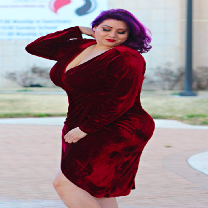 A reviewer wearing the V-neck dress in burgundy
