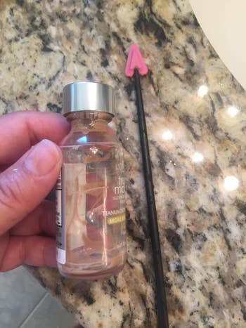 Reviewer photo of an empty foundation bottle next to the spatula