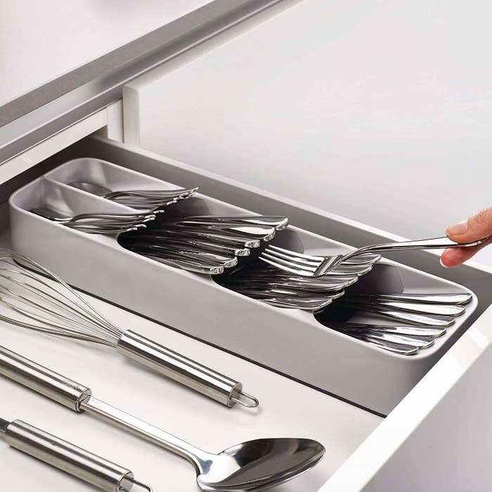 open kitchen drawer with narrow gray silverware organizer that&#x27;ll also spare lots of room for kitchen tools in the same drawer