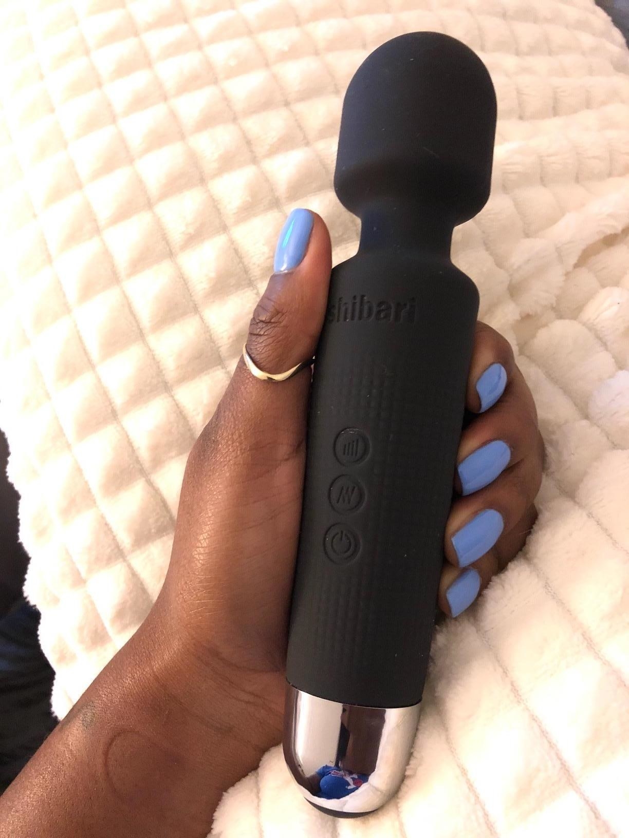Reviewer holding standard wand vibe in their hand