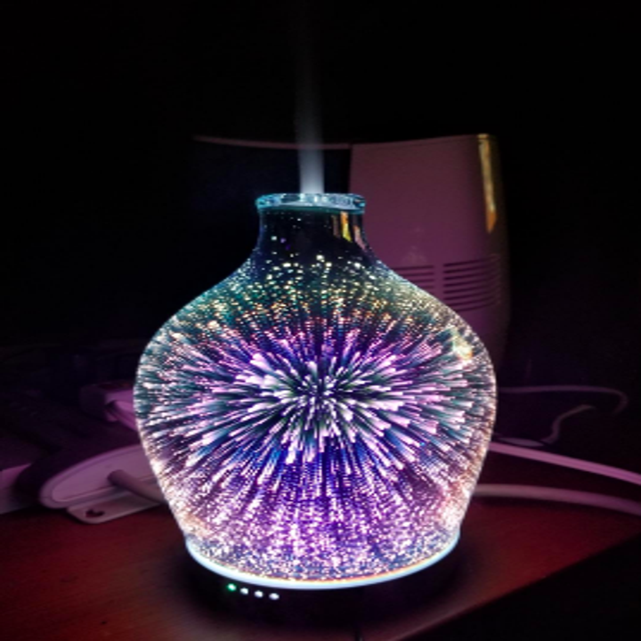 A reviewer's diffuser in the dark, showing cool tone lights in a firework pattern 