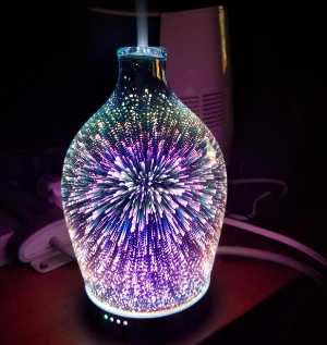 A reviewer&#x27;s diffuser in the dark, showing cool tone lights in a firework pattern 