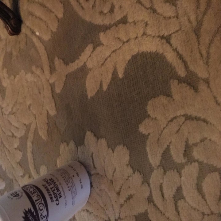 The same carpet with a bottle of the stain remover and no more stain