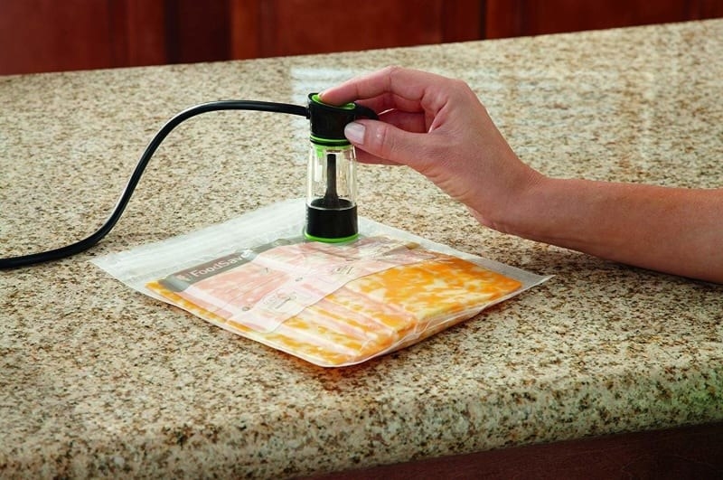 A model using a small vacuum sealer to suck the air out of a bag of cheese slices