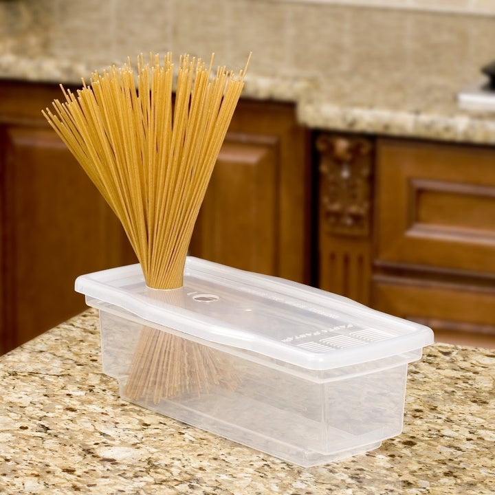 dry pasta being inserted into the pasta cooker