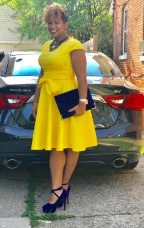 A reviewer wearing the cap sleeve, tie belt, fit-and-flare dress in yellow