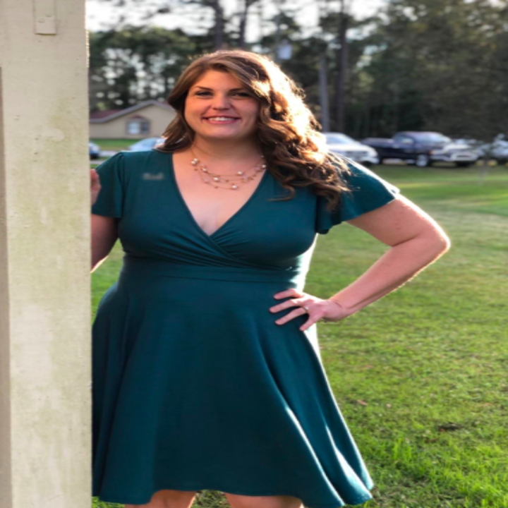 A reviewer wearing the V-neck dress in teal. It hits around their knee