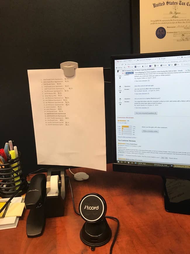 Reviewer photo of the clip holding a document, which is attached to a computer monitor