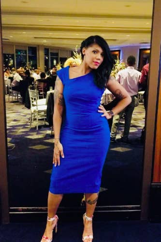 A reviewer wearing the sleeveless, asymmetric strap, below-the-knee dress in blue