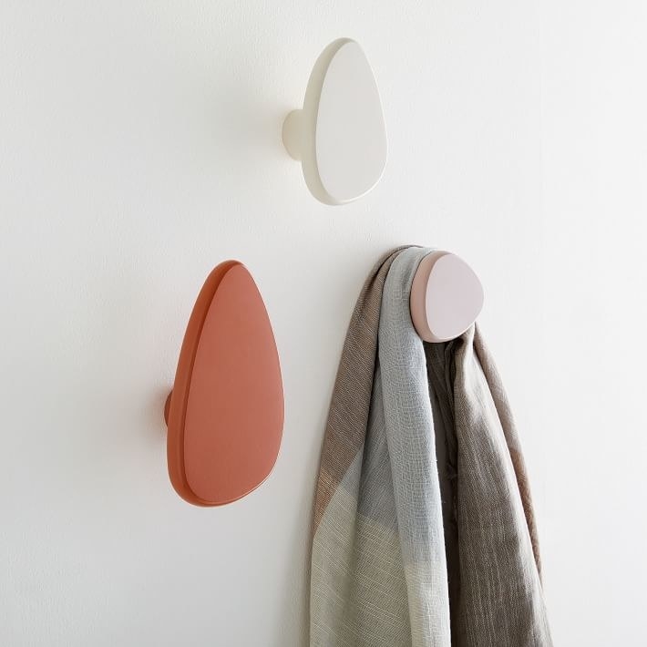 Pebble-style coat hooks in white, pink, and red