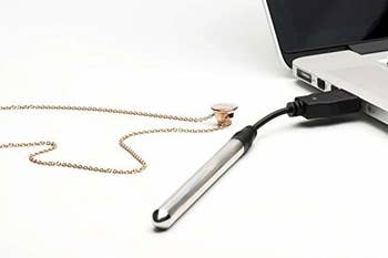 the vibrator necklace charging on a laptop