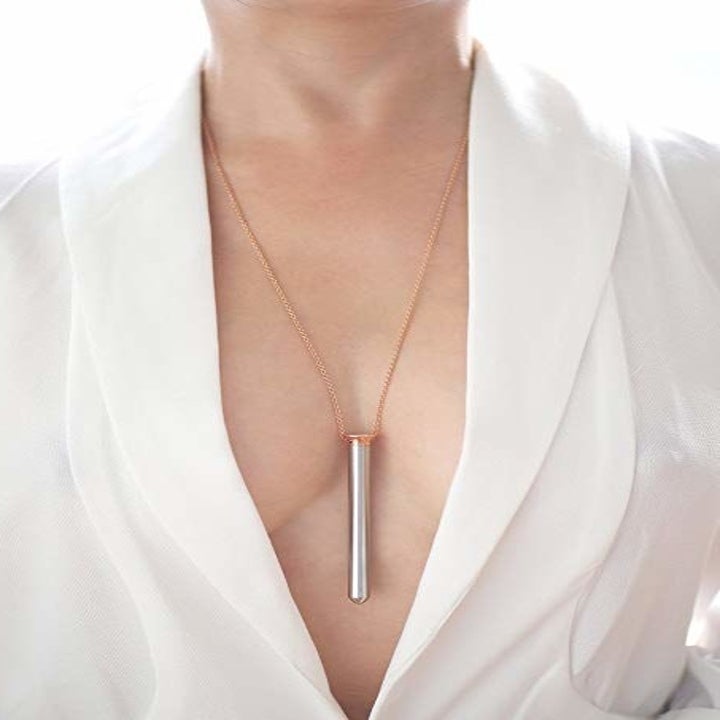 A model wearing the slim metal vibe on a chain around their neck