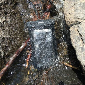 reviewer's phone in a waterproof pouch while underwater