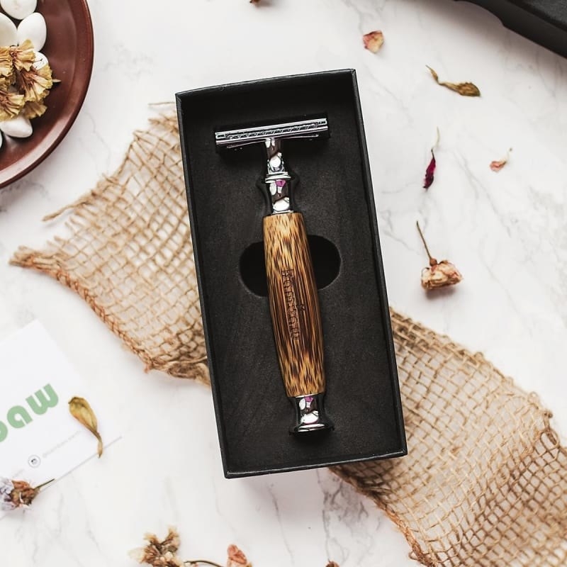 The razor with the bamboo handle in a box on a counter