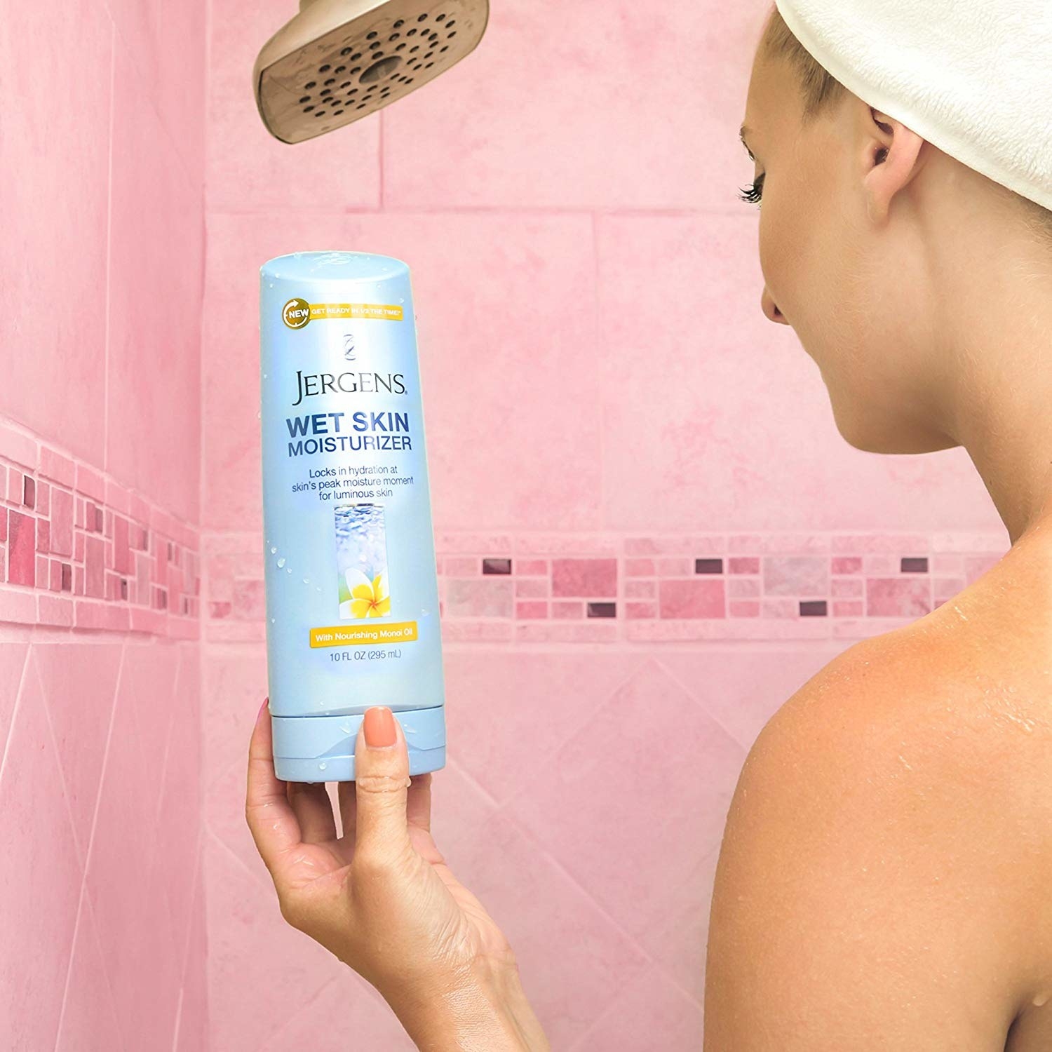 a model in a shower holding up a bottle of jergens wet skin moisturizer