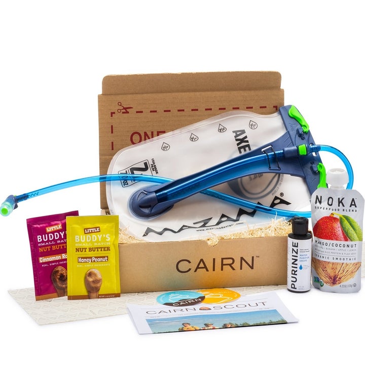 a box full of a water bladder, water purifying drops, a pouch of "superfood," and nut butter pouches