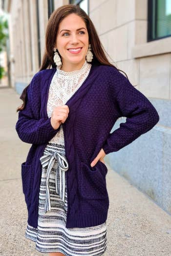 A reviewer wearing the buttonless navy cardigan with pockets