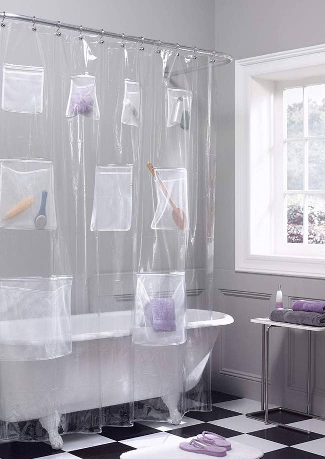 Shower curtain liner with pockets containing brushes and grooming products